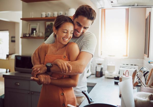 couple hugging, cooking in a kitchen 